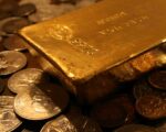 An image of a Gold Bar sitting on Gold Coins