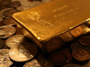 An image of a Gold Bar sitting on Gold Coins